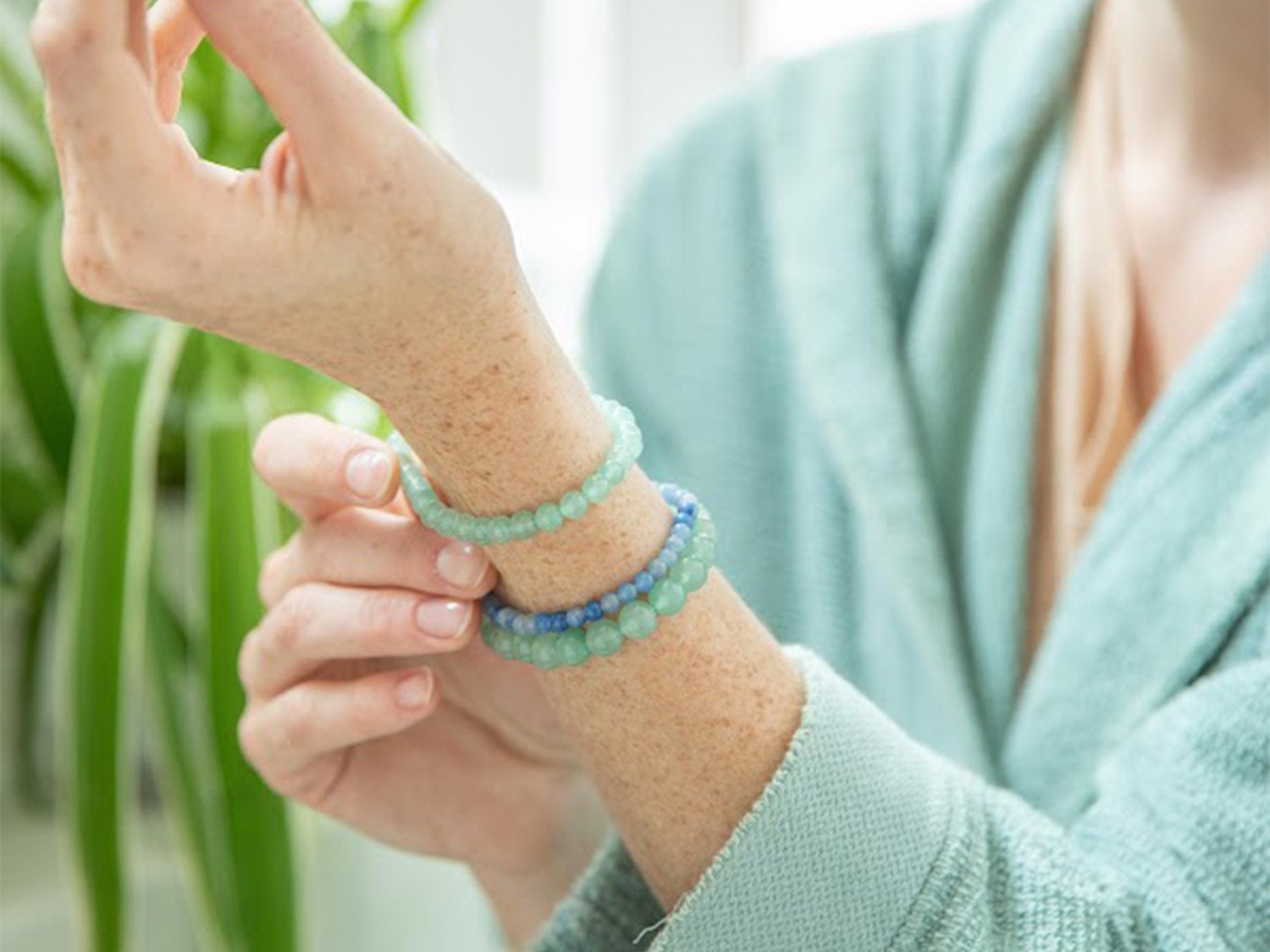 Une femme en train de regarder ses trois bracelets de lithothérapie