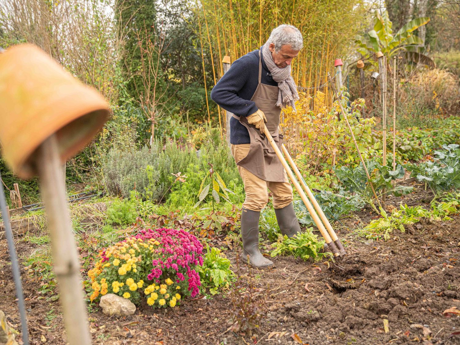 Un homme en train de labourer la terre de son jardin