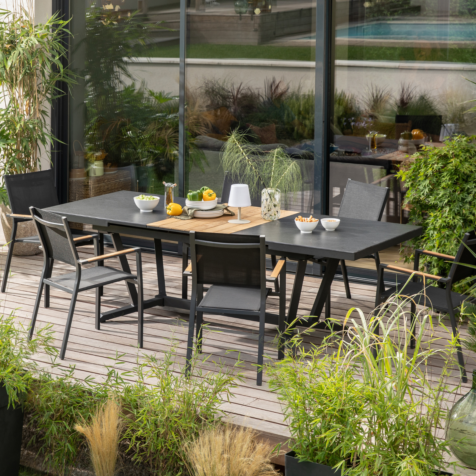 Table de jardin de couleur noir avec ses chaises sur une terrasse