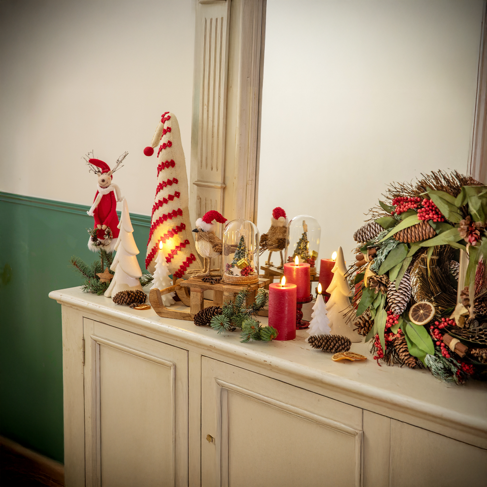 Des décorations de Noël rouges et blanches installées sur un meuble de salon