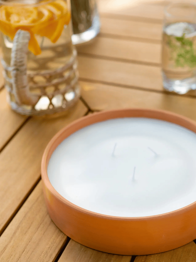 Une bougie à la citronnelle dans un pot en terre cuite