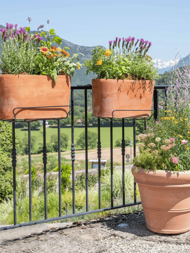 Deux jardinières fleuries sur une rambarde de balcon