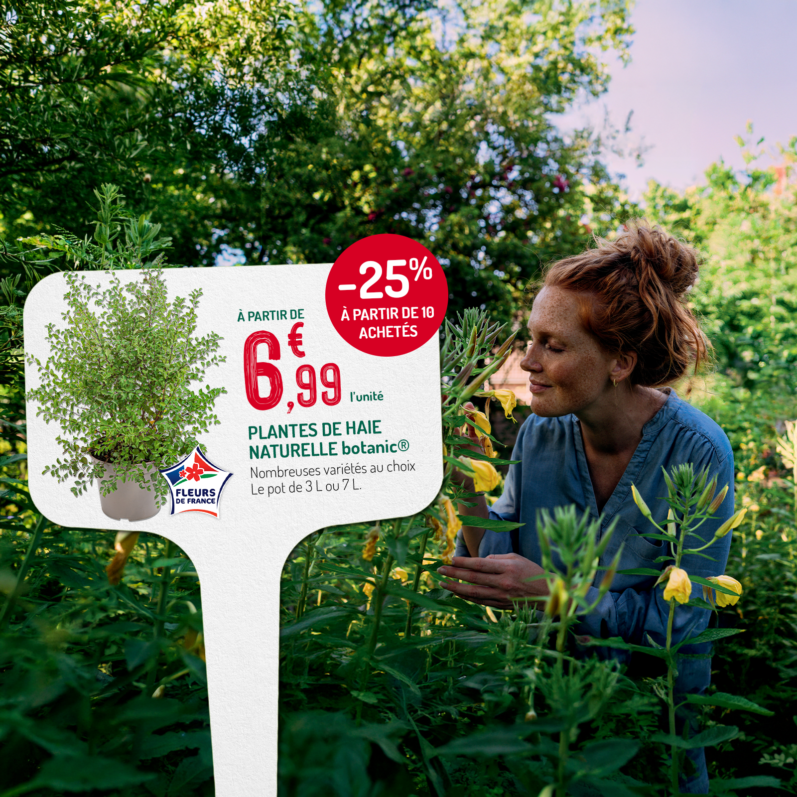 Une femme au milieu d'un jardin fleuri en train de sentir l'odeur des fleurs