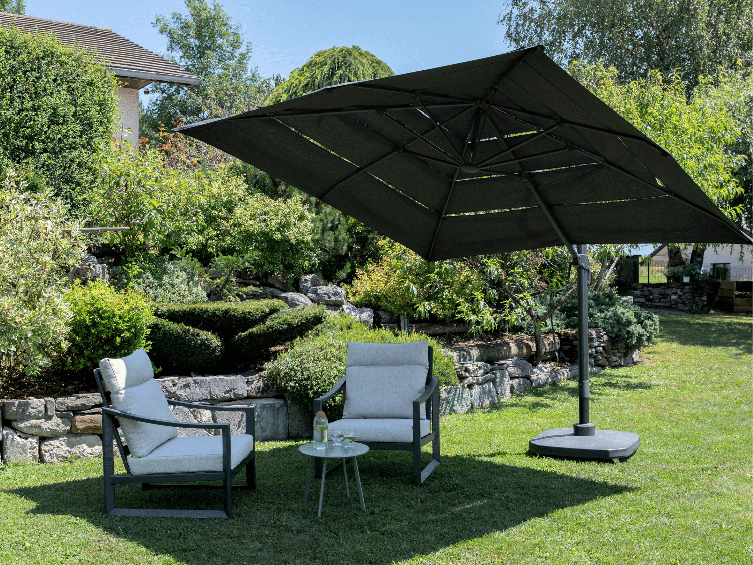 Parasol quoi fait des l'ombre sur deux chaises de jardin.