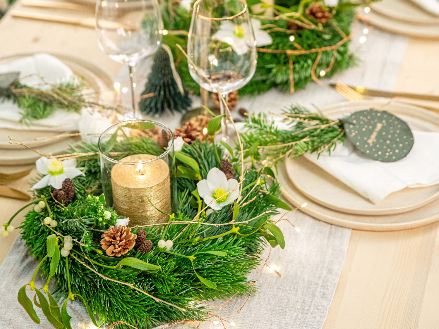 Table de Noël décoré avec un centre de table en branches sapin et une bougie