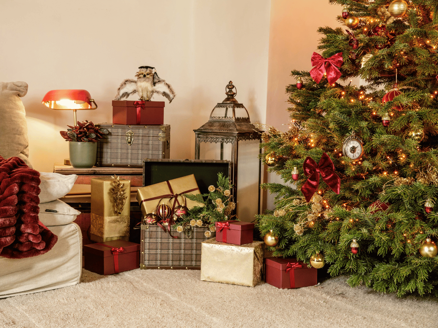 Un salon de Noël aux couleurs bordeaux et or avec une pile de cadeaux et un sapin