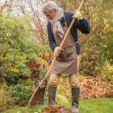 Homme qui ramasse les feuilles dans son jardin