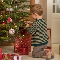 Un petit garçon entrain d'ouvrir ses cadeaux de Noël