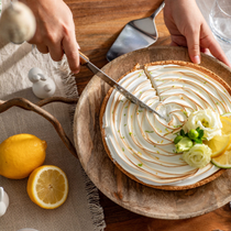 Une table de pâques décorée au style campagne, avec un zoom sur une femme en train de couper une tarte au citron