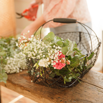 Un panier contenant des fleurs sur une table.