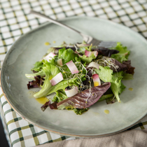 Une salade servit dans une assiette vert d'eau