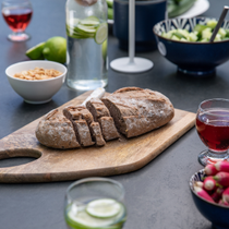 Du pain découpé sur une planche posée sur une table de jardin