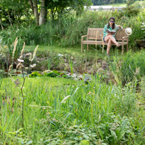 Une femme lisant sur son banc au jardin