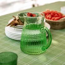Un pichet vert sur une table d'été