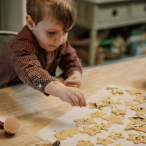 Un enfant qui décore ses sablés pour Noël
