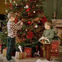 Des enfants en train de décorer le sapin de Noël