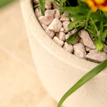 Zoom su le côté d'un pot blanc en pierre remplis de cailloux blanc