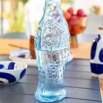 Une carafe d'eau en forme de poisson posé sur une table