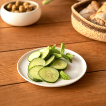 Assiette avec du concombre, de la menthe et une corbeille de pain