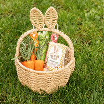 Un panier en rotin rempli de chocolats de Pâques dans le jardin