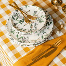 Les assiettes champêtre empilées avant le dressage de la table