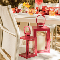 Deux lanternes colorées fuchsia Arana posées sur une chaise extérieure