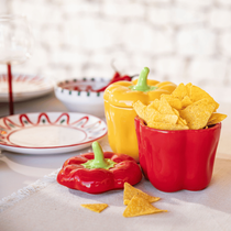 Un récipient en forme de poivron avec des chips pour l'apéritif sur une table