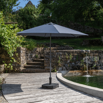 Parasol droit gris au bord d'une piscine naturelle