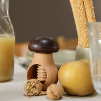 Un tire bouchon en bois en forme de champignon et une noix et une pomme
