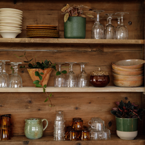 Zoom sur une étagère en bois avec des verres, des bols et des assiettes