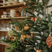 Un sapin de noel décoré avec des boules vertes et brunes