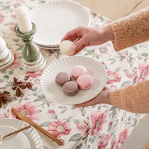 Une femme en train de servir des macarons dans une assiette blanche