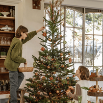 Un sapin de Noël en train d'être décoré par des enfants