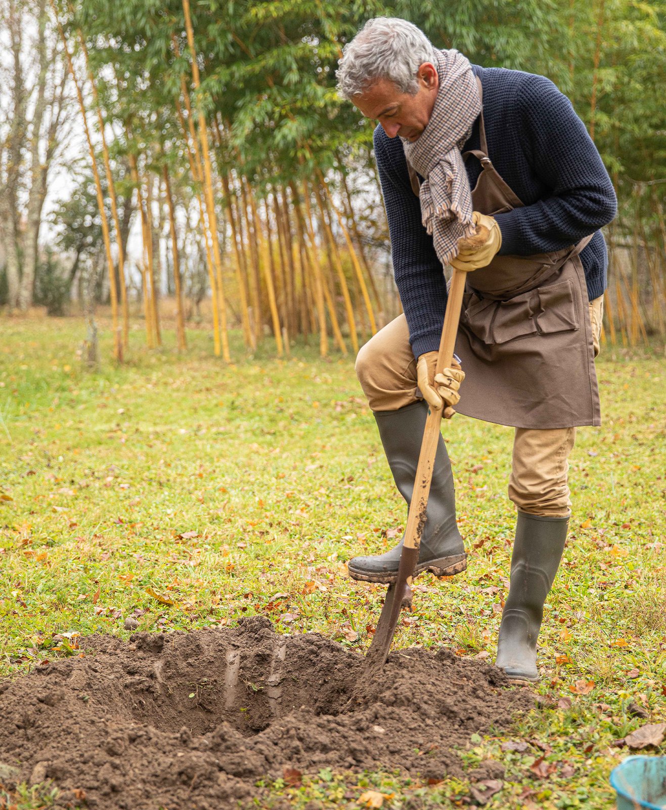 Un homme qui creuse un trou pour planter un arbre fruitier
