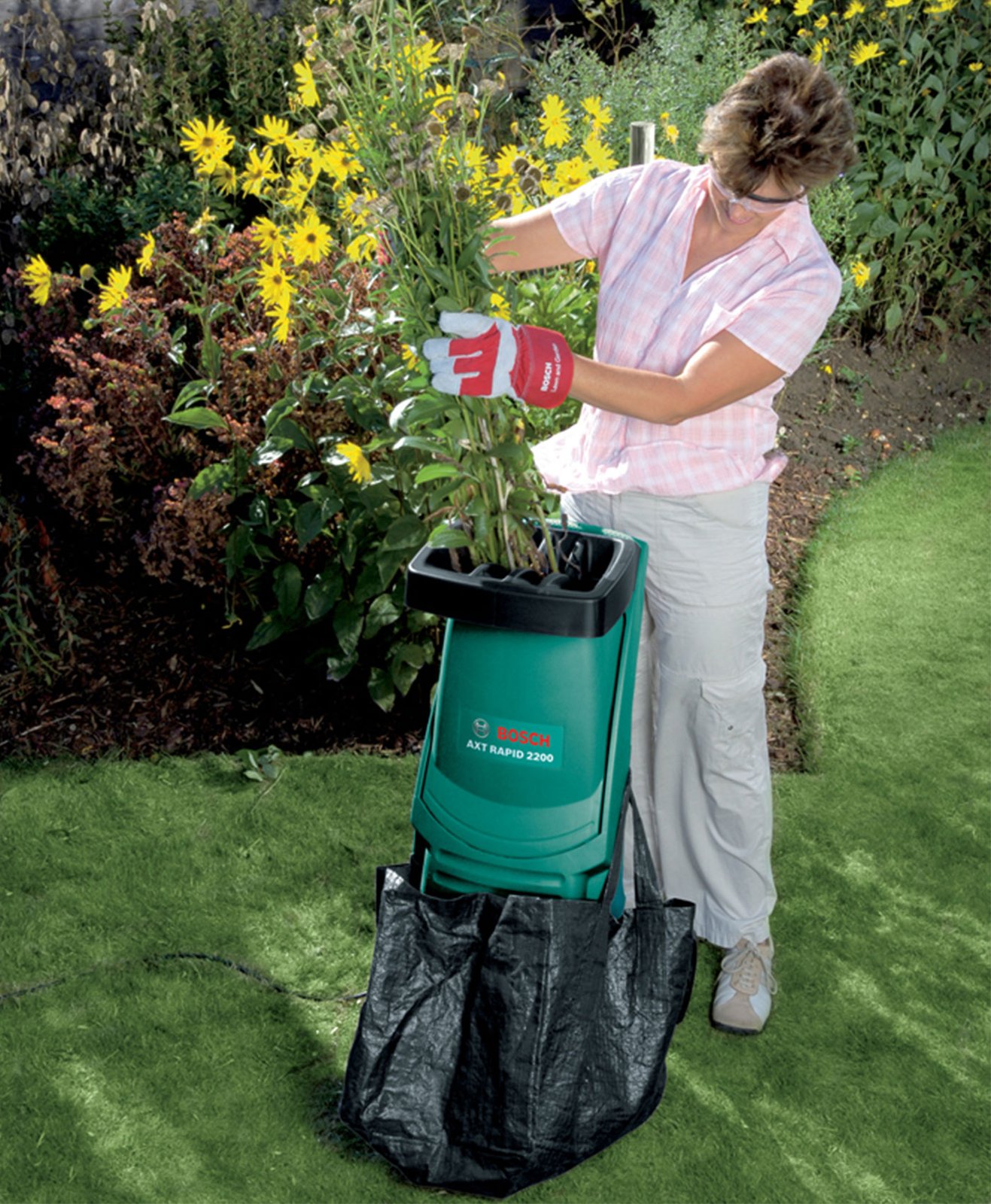 Une femme broie ses déchets végétaux du jardin