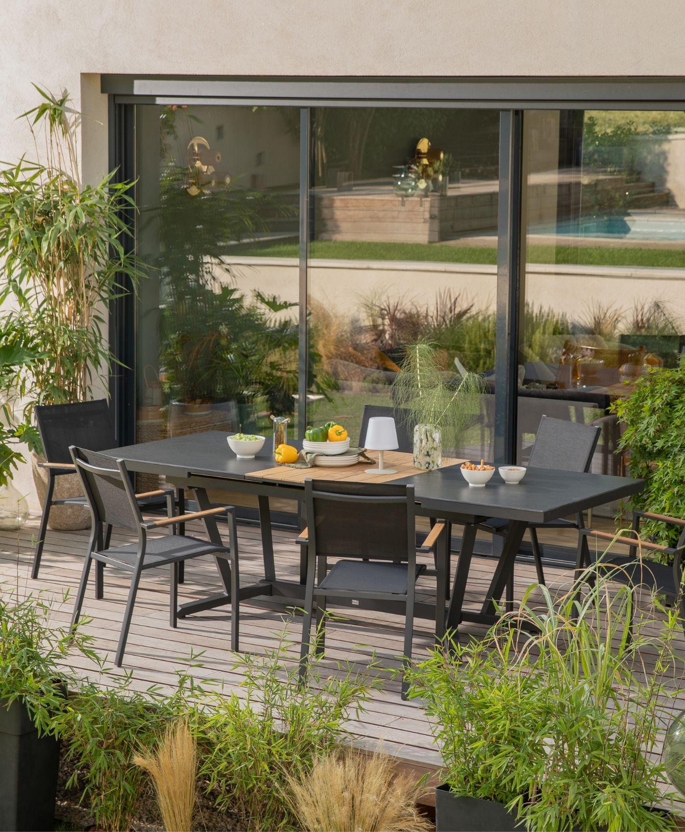Une table de jardin en bois et métal sur une terrasse