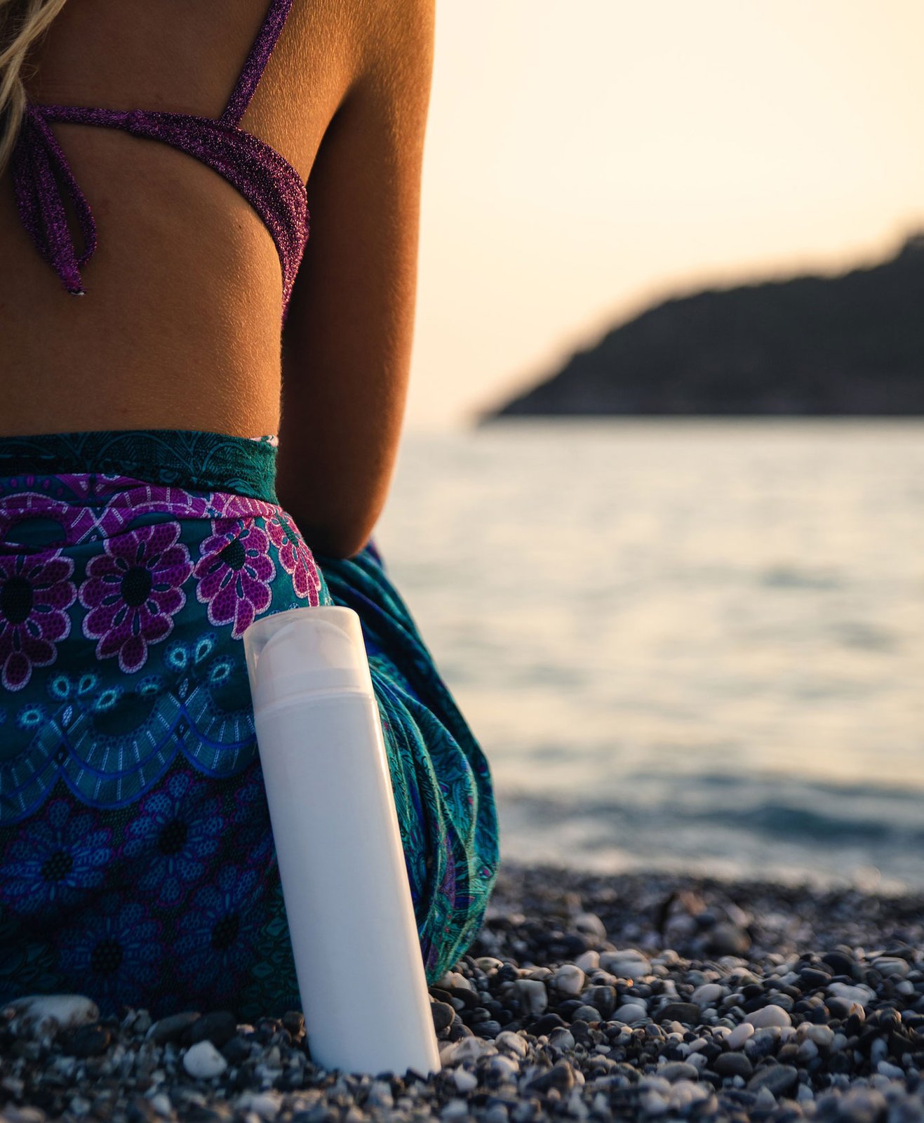 Une femme sur une plage avec un pot de crème solaire