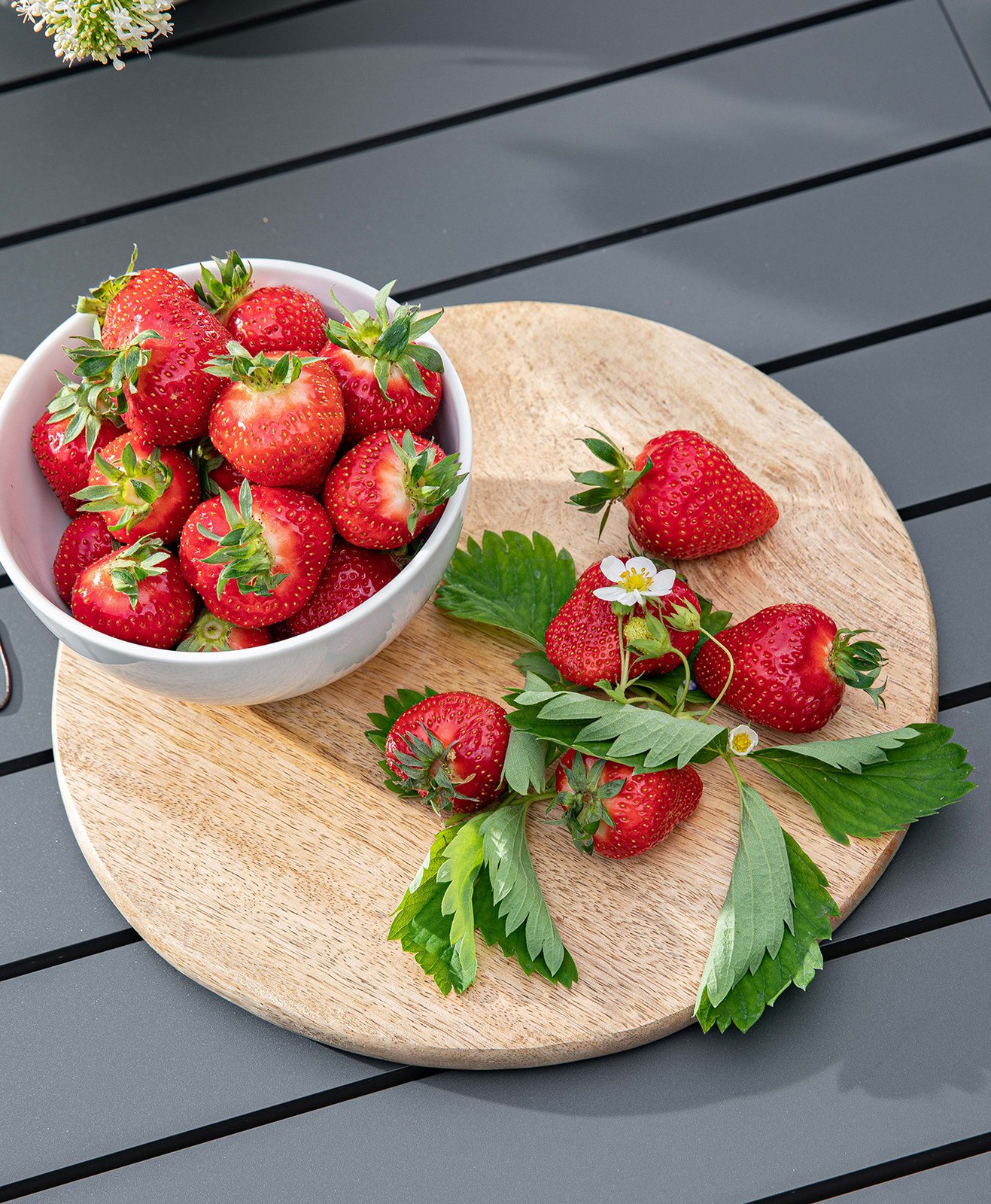 Des fraises entières sur une planche à découpé en bois