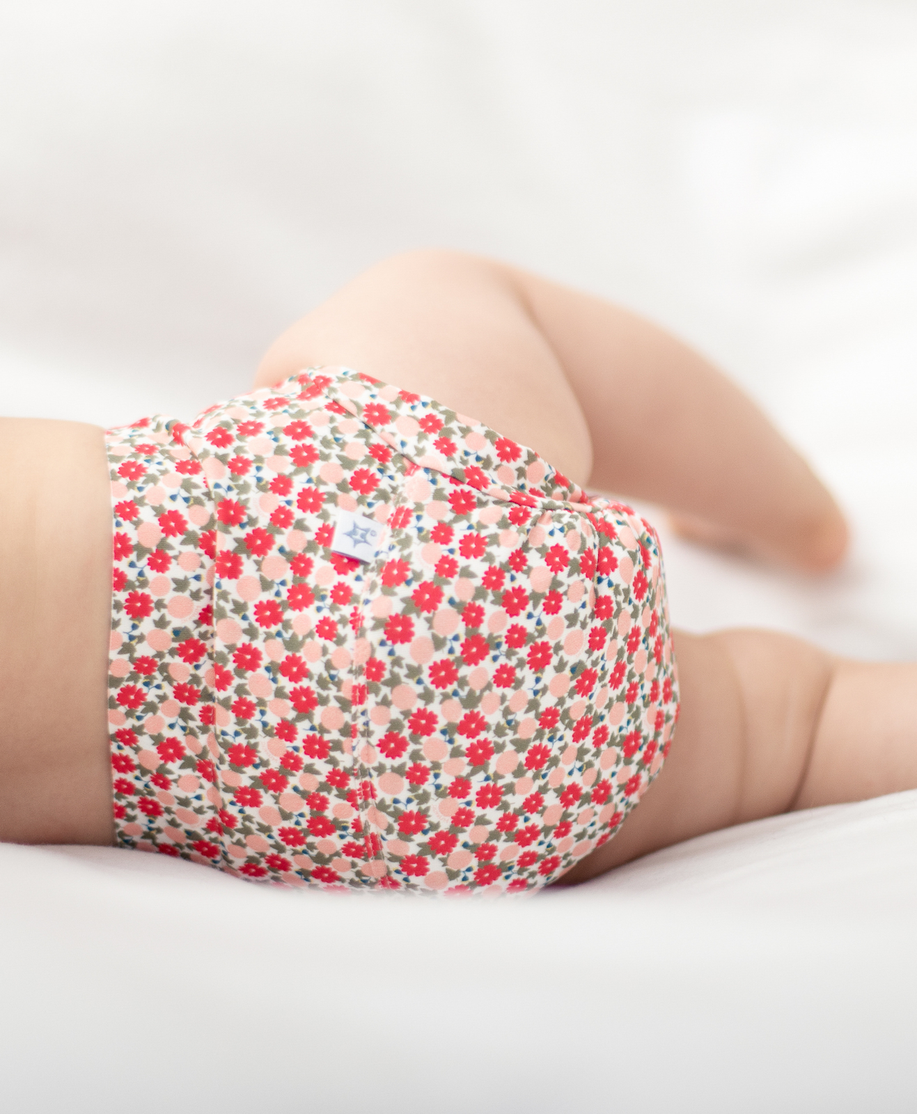 Un bébé avec une couche hamac fleurie