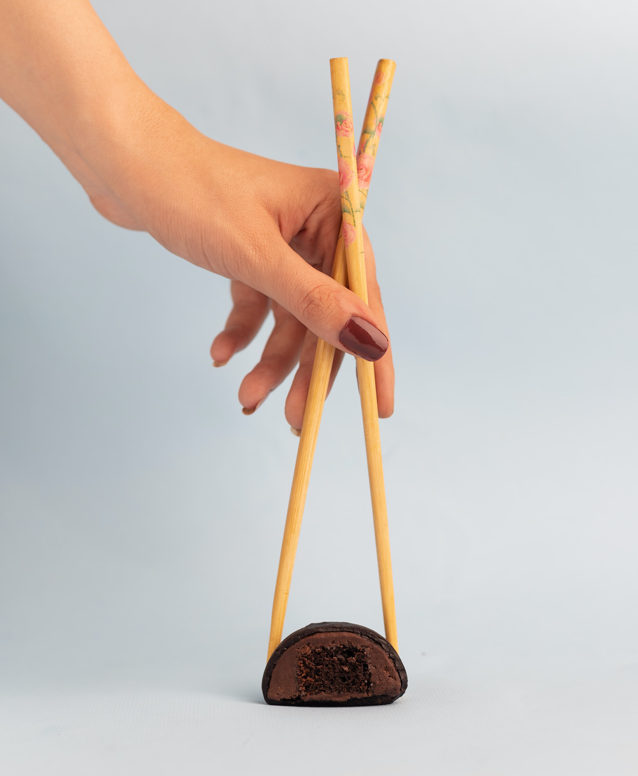 Une personne prend un mochi avec des baguettes chinoises