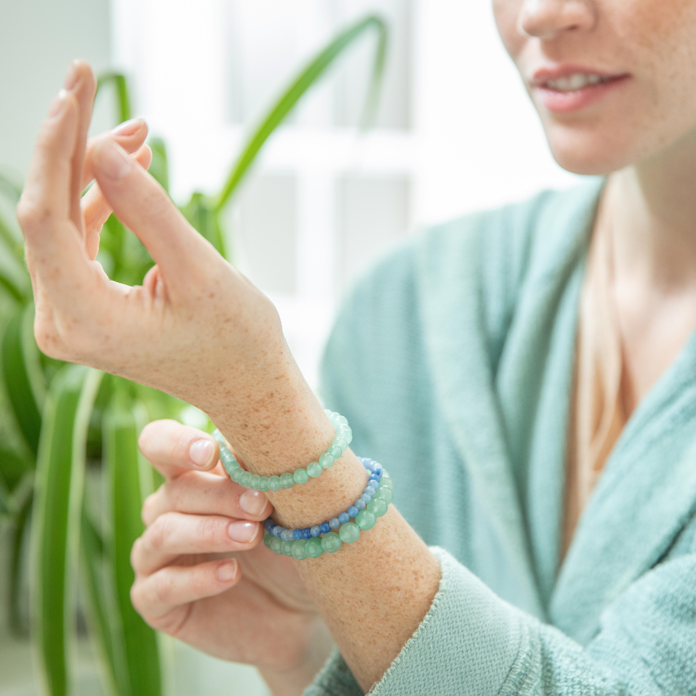 Femme qui regarde ses bracelets de lithothérapie