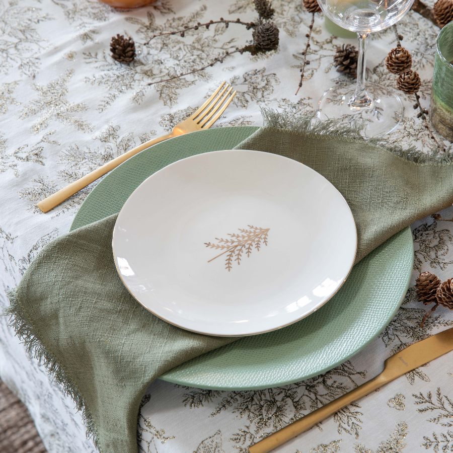 Petite assiette blanche posée sur une plus grande assiette verte