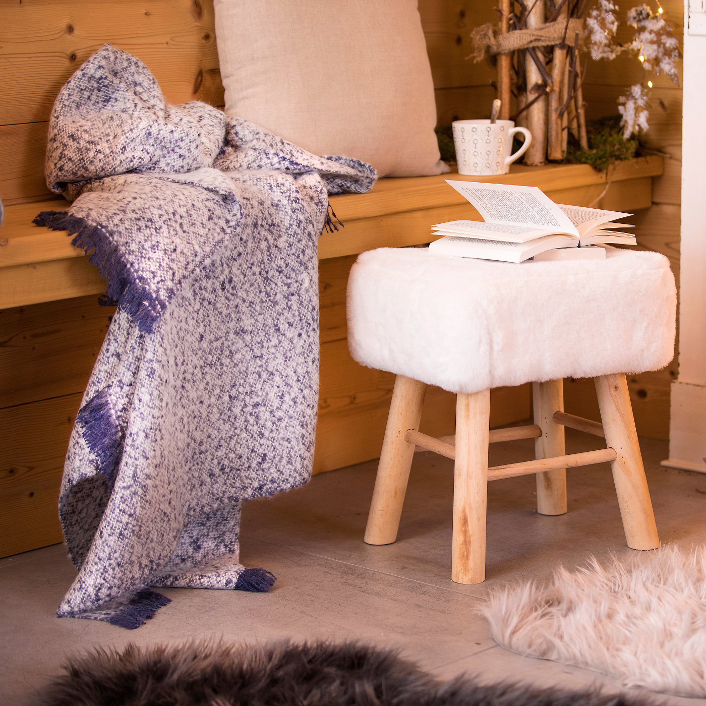 Coin cocooning avec plaid et coussins et boisson chaude