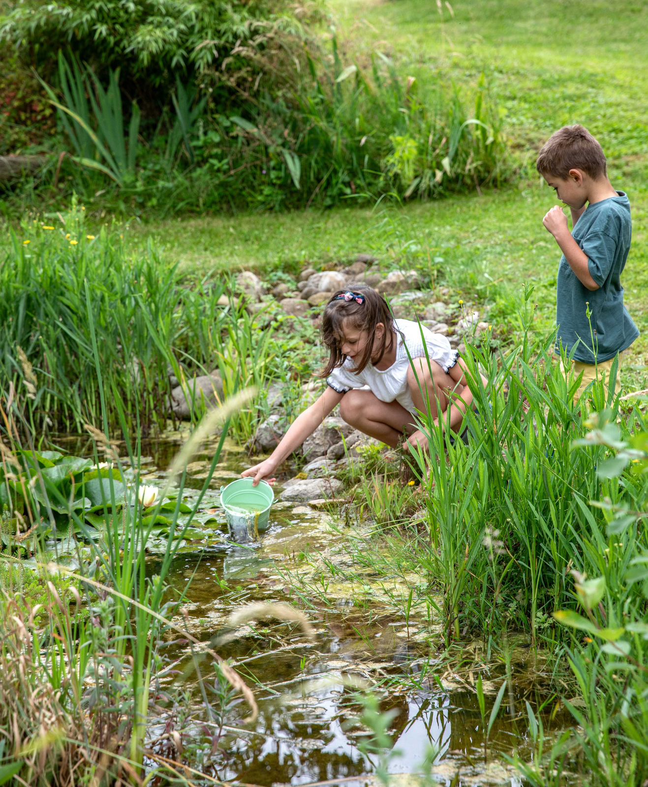 Une mare au jardin et des enfants qui jouent