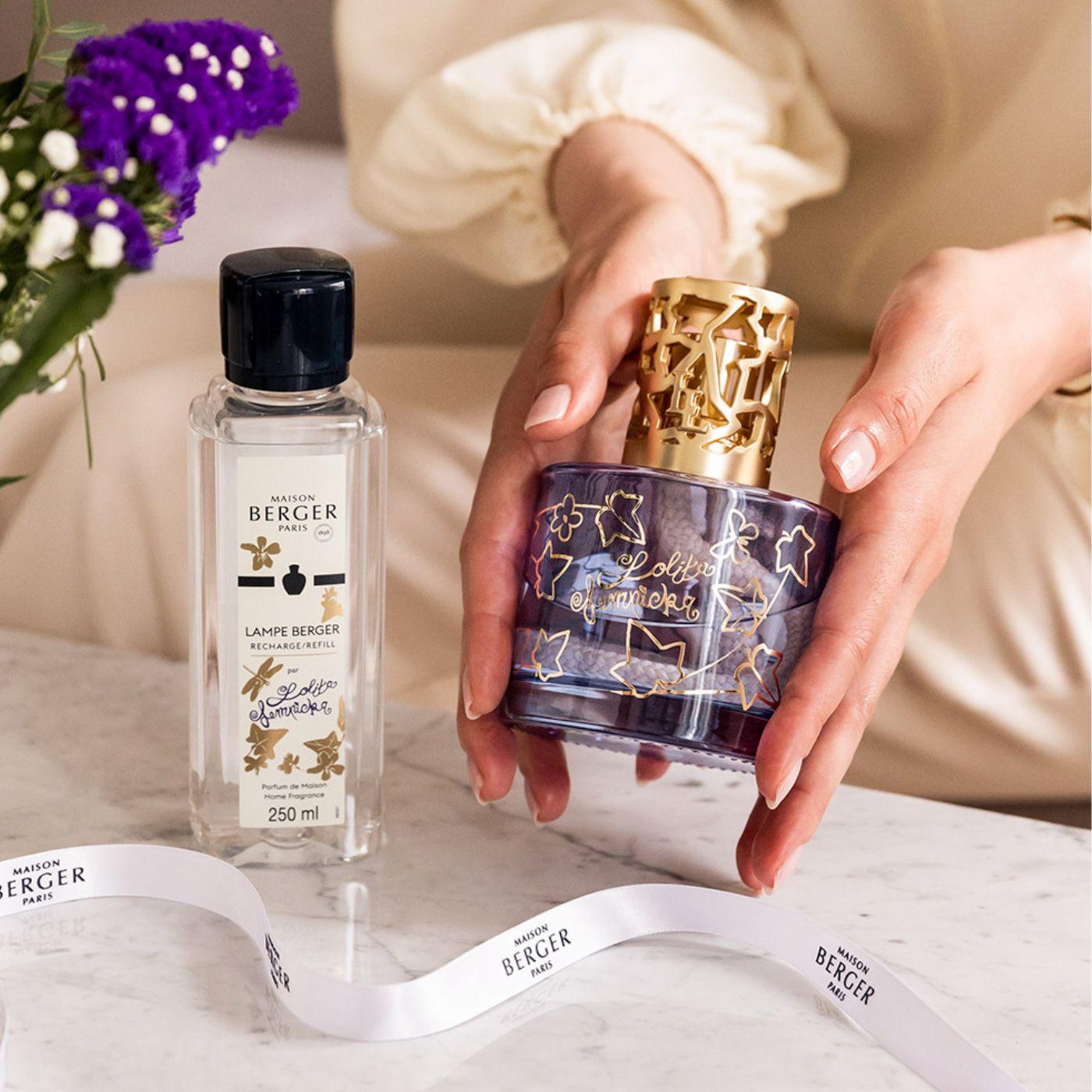 Femme qui tient un diffuseur de parfum violet avec une recharge