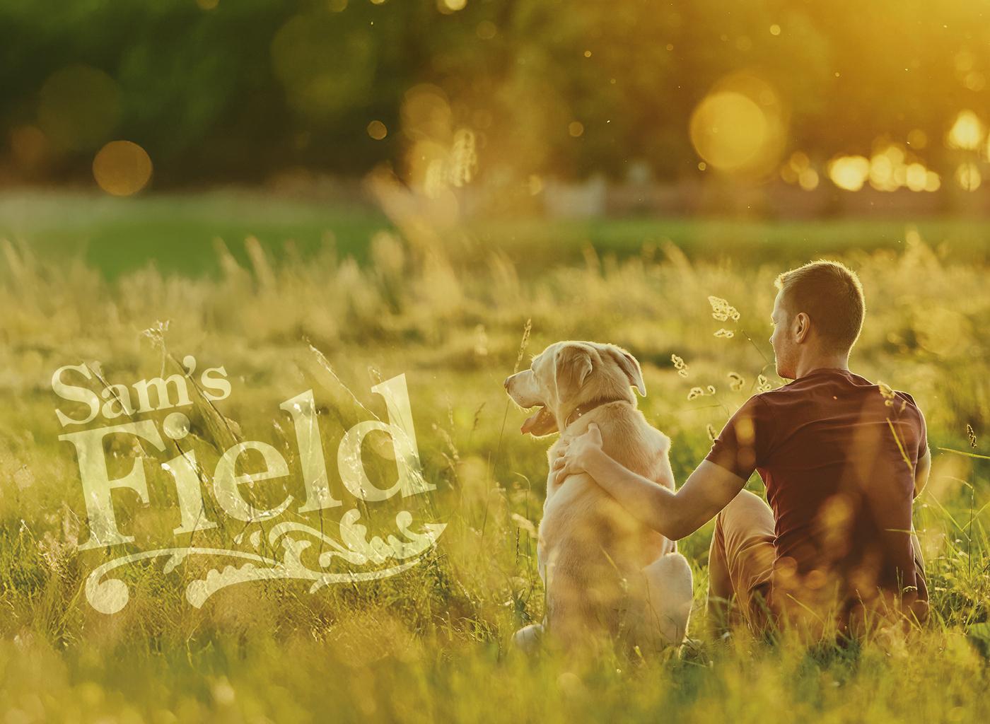Homme et son chien assis dans un champ