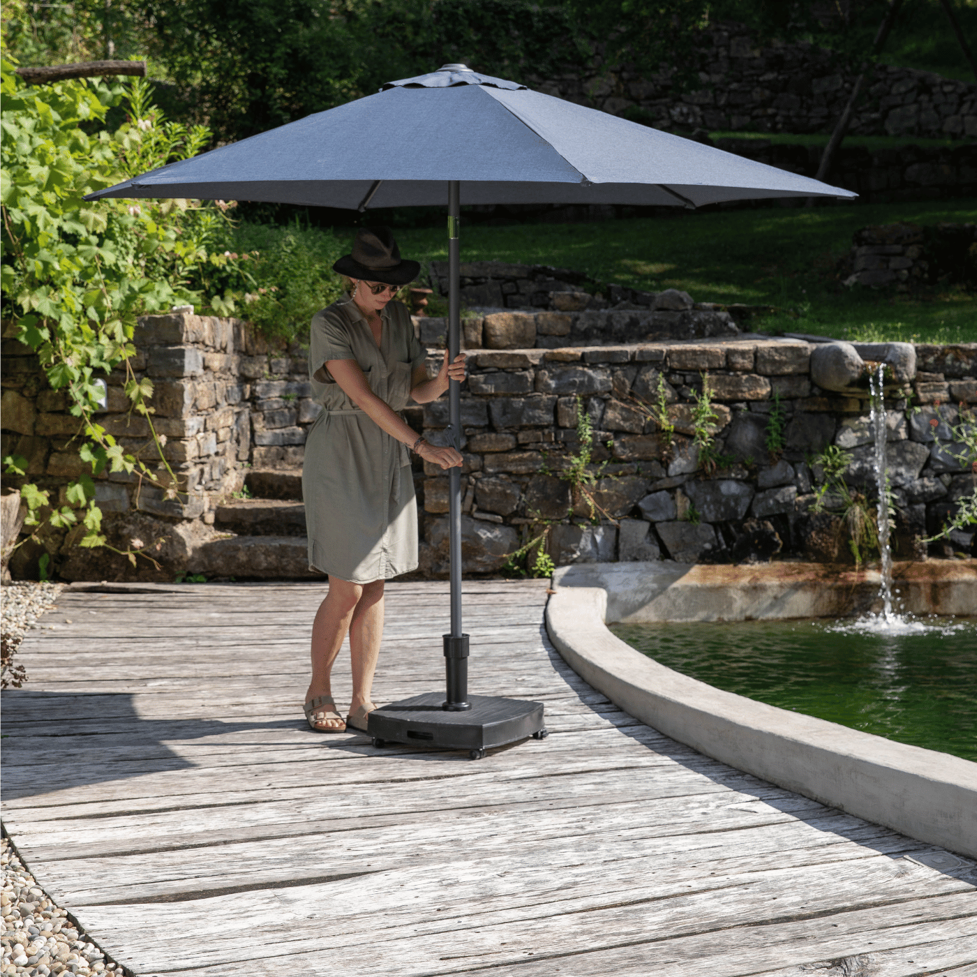 Une femme se protège du soleil sous un parasol