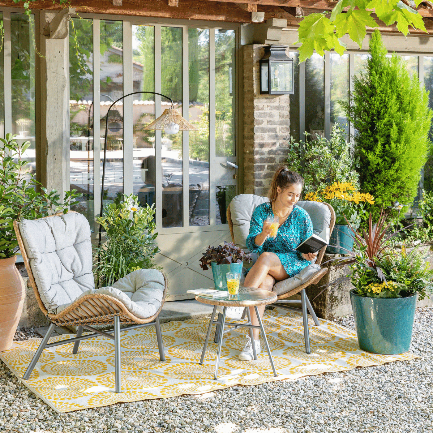 Une femme lit un livre sur la terrasse