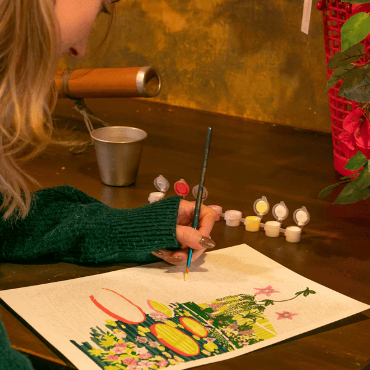 Femme qui fait de la peinture aux numéros sur une table