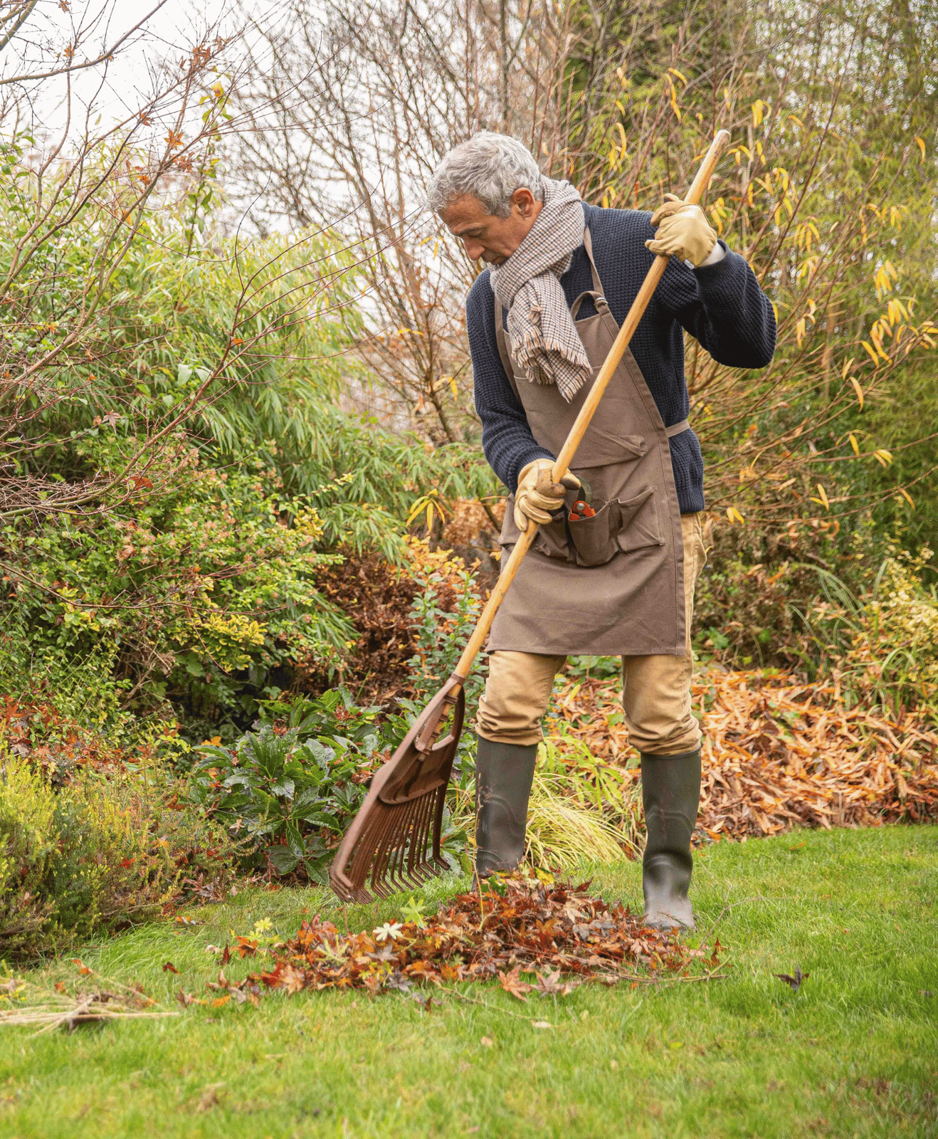 homme qui ramasse les feuilles mortes en automne